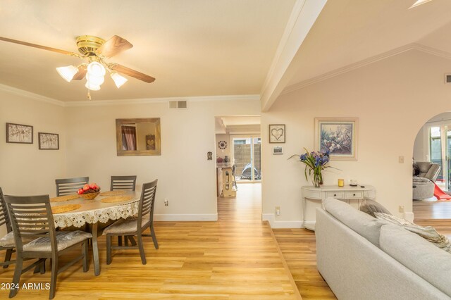 dining space with ornamental molding, vaulted ceiling, light hardwood / wood-style flooring, and ceiling fan