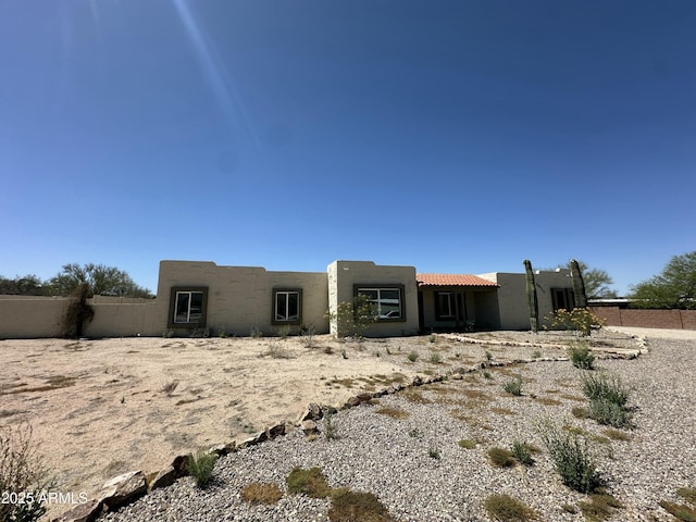 pueblo revival-style home with fence