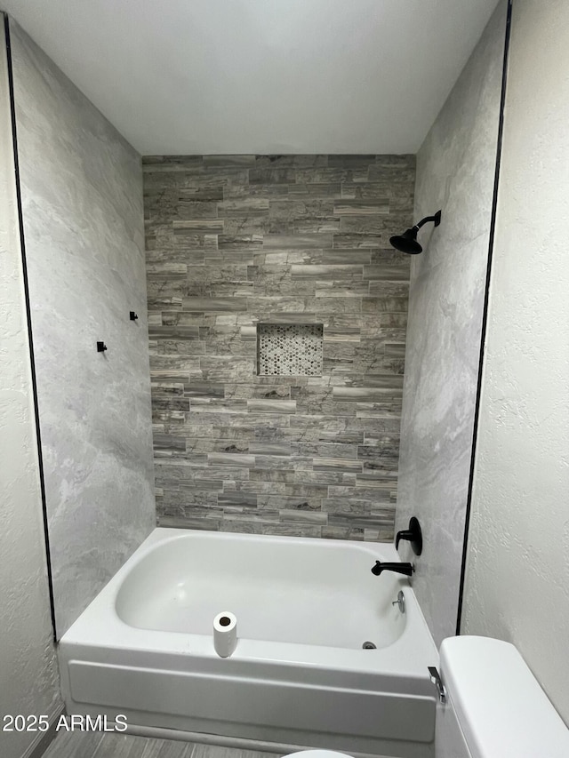 full bath featuring toilet and washtub / shower combination