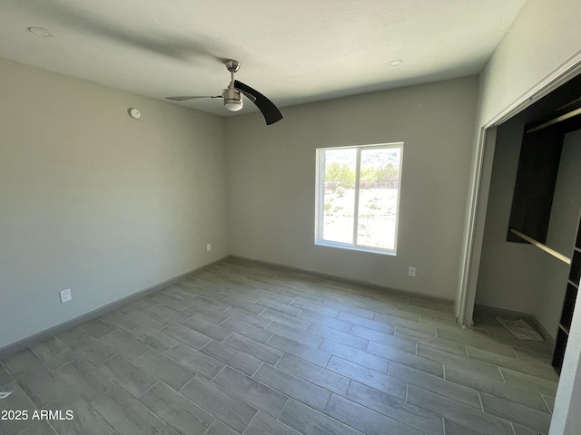 interior space featuring a ceiling fan and baseboards
