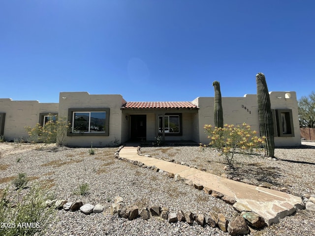 pueblo-style house with a tiled roof