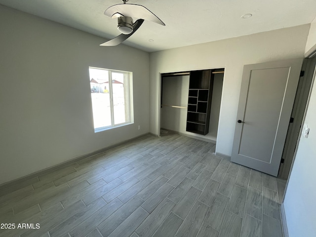 unfurnished bedroom featuring a closet, baseboards, and wood finished floors