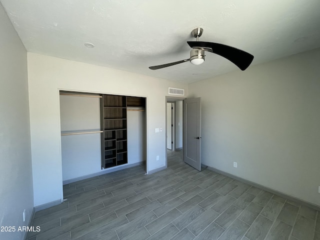 unfurnished bedroom with a closet, visible vents, wood finished floors, and baseboards
