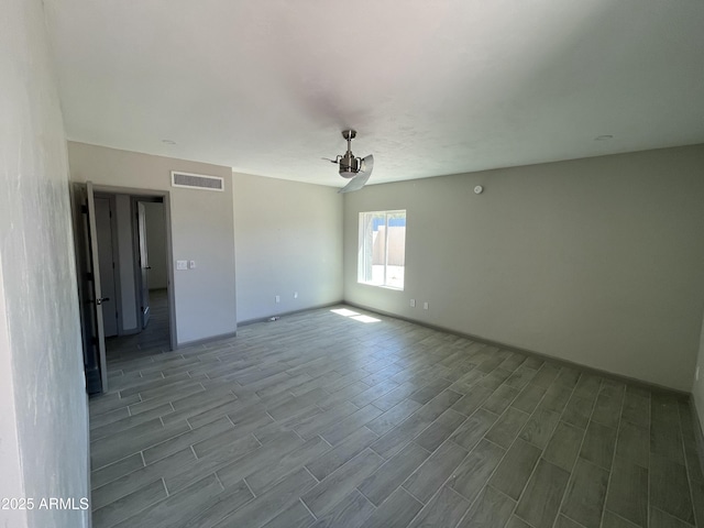 spare room featuring visible vents, wood finished floors, and baseboards