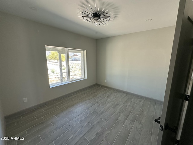 unfurnished room with baseboards and wood finished floors