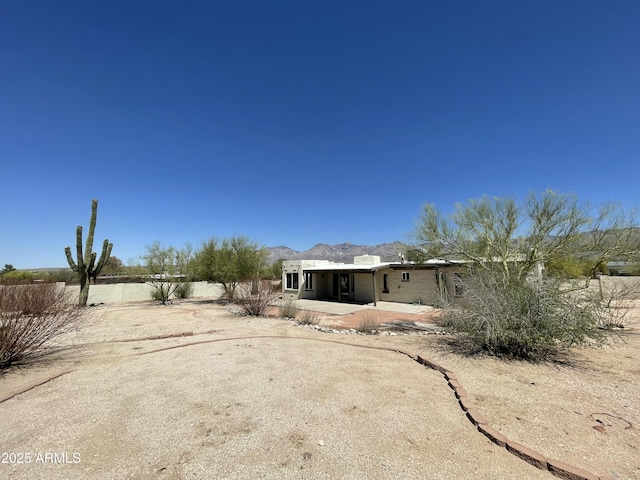 rear view of property featuring a fenced backyard, a patio area, and a mountain view