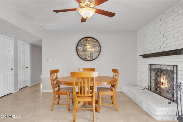 dining space featuring a brick fireplace, visible vents, baseboards, and light tile patterned flooring