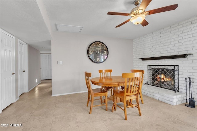 dining area with visible vents, a fireplace, a textured ceiling, and baseboards