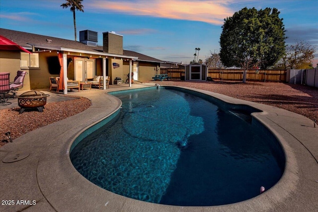 view of swimming pool featuring a fenced in pool, an outdoor fire pit, a patio area, cooling unit, and a fenced backyard