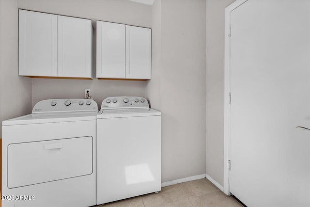 washroom featuring light tile patterned floors, independent washer and dryer, cabinet space, and baseboards