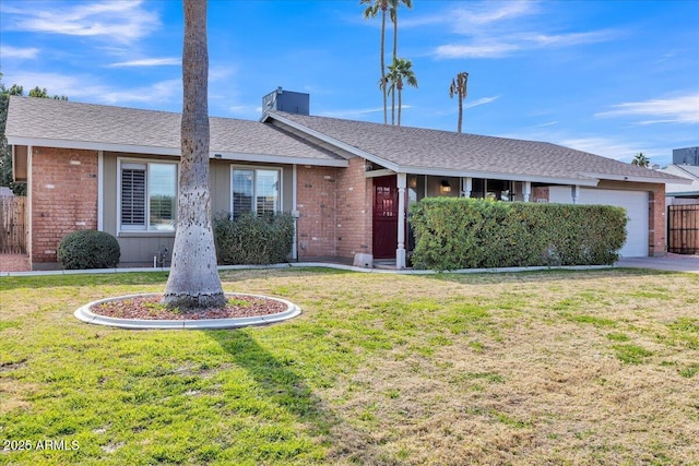 ranch-style home with a garage, brick siding, roof with shingles, and a front yard