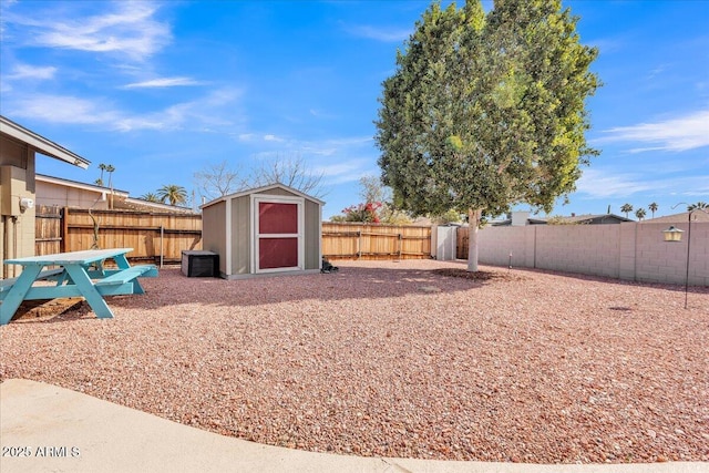 view of yard with an outbuilding, a storage unit, and a fenced backyard