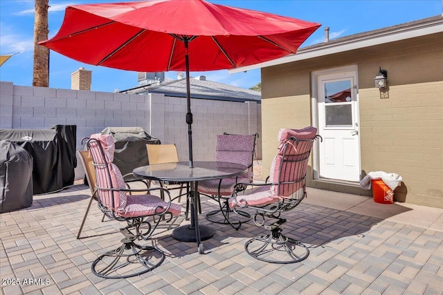 view of patio with outdoor dining area and fence