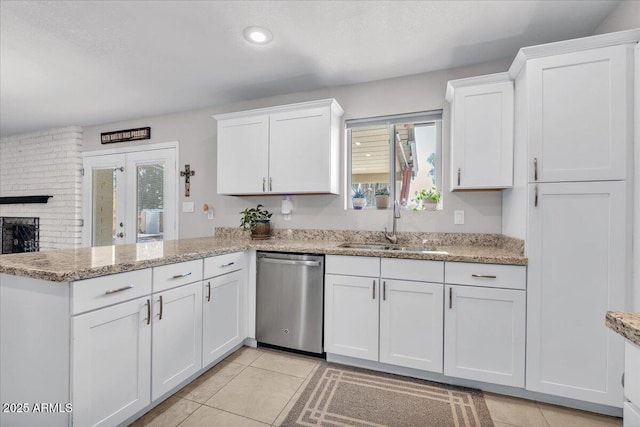 kitchen with a peninsula, a sink, white cabinets, and dishwasher