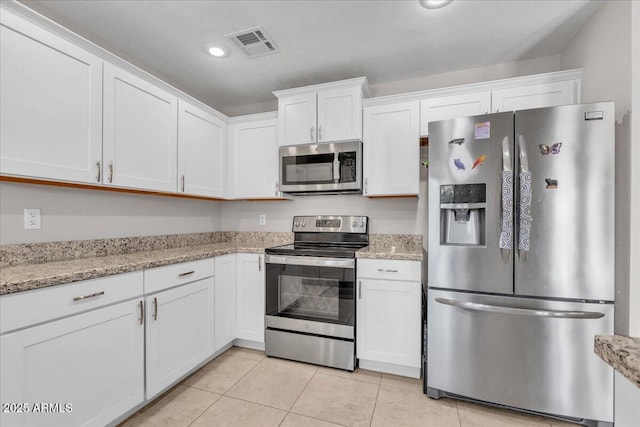 kitchen featuring light tile patterned floors, white cabinetry, visible vents, and stainless steel appliances