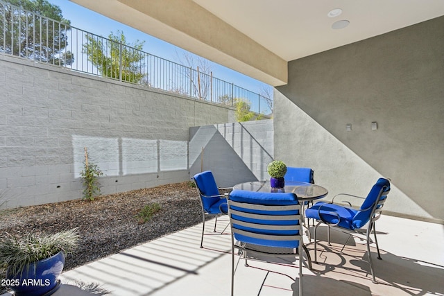 view of patio with outdoor dining area and fence