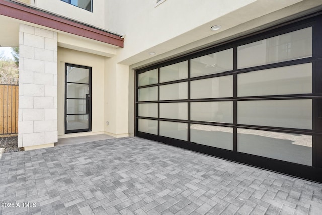 exterior space featuring fence and decorative driveway