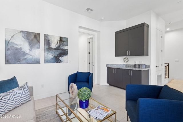 living area featuring light tile patterned flooring, visible vents, and recessed lighting