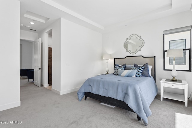 carpeted bedroom with baseboards, visible vents, and a tray ceiling