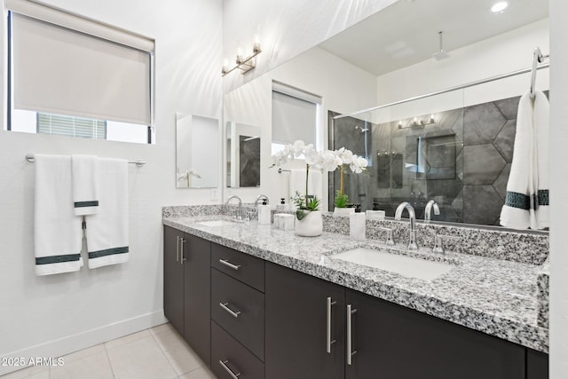 bathroom featuring baseboards, a sink, tile patterned floors, and a stall shower