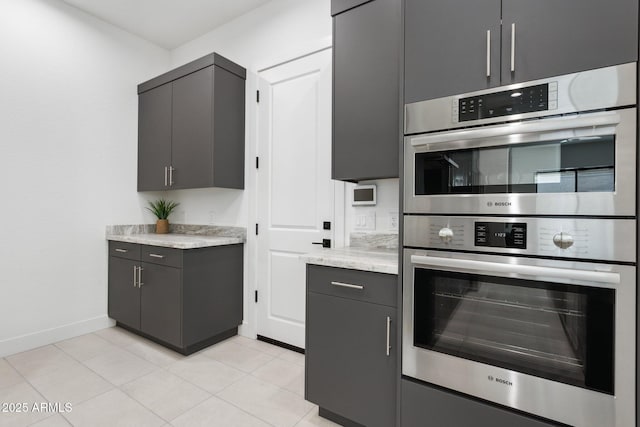 kitchen featuring double oven, baseboards, and light tile patterned floors