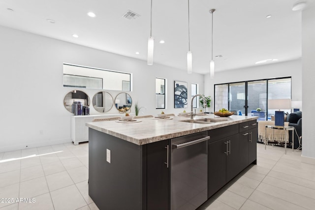 kitchen featuring visible vents, dishwasher, a sink, dark cabinets, and an island with sink