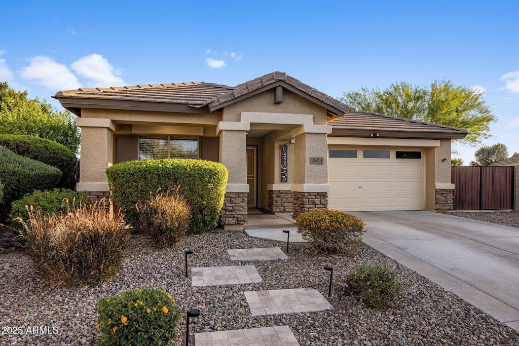 2823 E Charlotte Dr, Phoenix, AZ 85024 - view of front of property featuring a tile roof, driveway, stone siding, an attached garage, and stucco siding