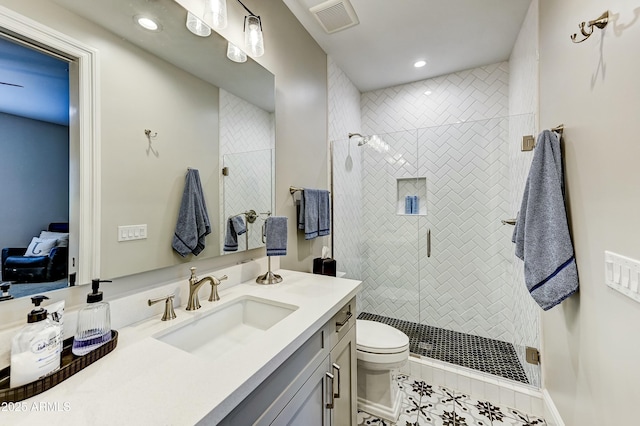 bathroom featuring toilet, tile patterned flooring, vanity, and a shower with door