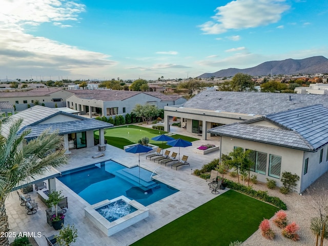 rear view of house with a mountain view, a patio area, and a fire pit