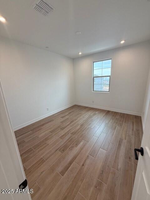 spare room with light hardwood / wood-style flooring