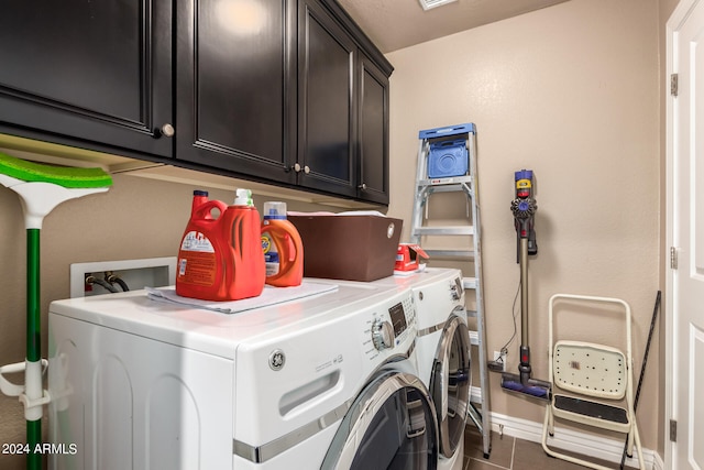 laundry room with cabinets, independent washer and dryer, and dark tile patterned floors