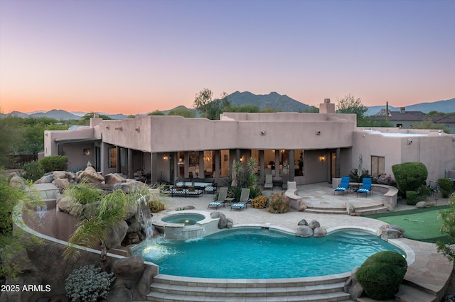 7025 E Ashler Hills Dr, Scottsdale, AZ 85266 - pool at dusk with a patio, a putting green, a mountain view, and a pool with connected hot tub