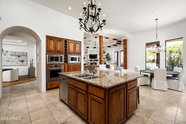 7025 E Ashler Hills Dr, Scottsdale, AZ 85266 - kitchen with a sink, appliances with stainless steel finishes, a chandelier, arched walkways, and light stone counters