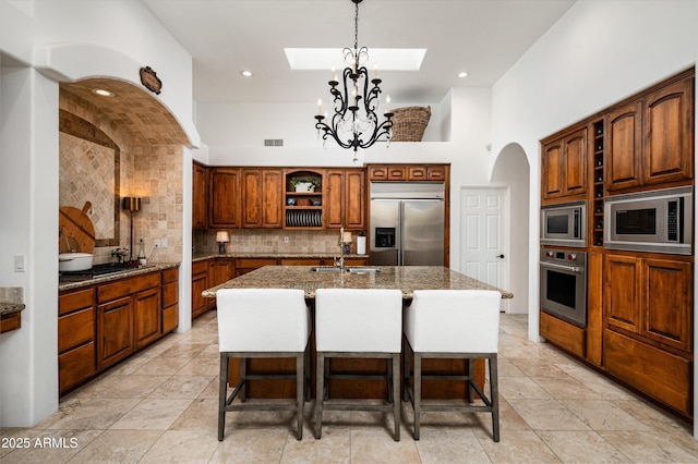 7025 E Ashler Hills Dr, Scottsdale, AZ 85266 - kitchen featuring built in appliances, open shelves, a sink, a skylight, and decorative backsplash