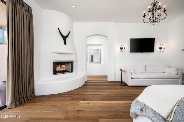 7025 E Ashler Hills Dr, Scottsdale, AZ 85266 - living room with wood finished floors, a glass covered fireplace, a chandelier, and recessed lighting