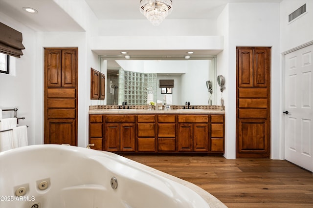 7025 E Ashler Hills Dr, Scottsdale, AZ 85266 - bathroom featuring wood finished floors, double vanity, a whirlpool tub, recessed lighting, and a shower with door
