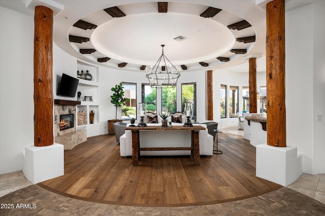 7025 E Ashler Hills Dr, Scottsdale, AZ 85266 - living area featuring built in shelves, wood-type flooring, a chandelier, and a stone fireplace