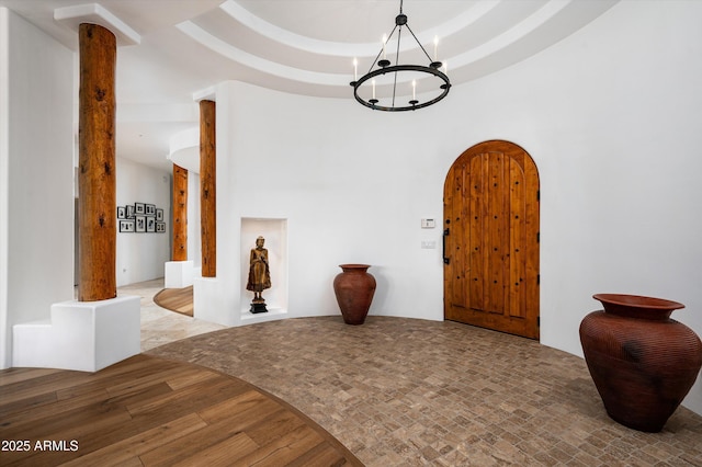 7025 E Ashler Hills Dr, Scottsdale, AZ 85266 - foyer featuring a chandelier, arched walkways, and wood finished floors