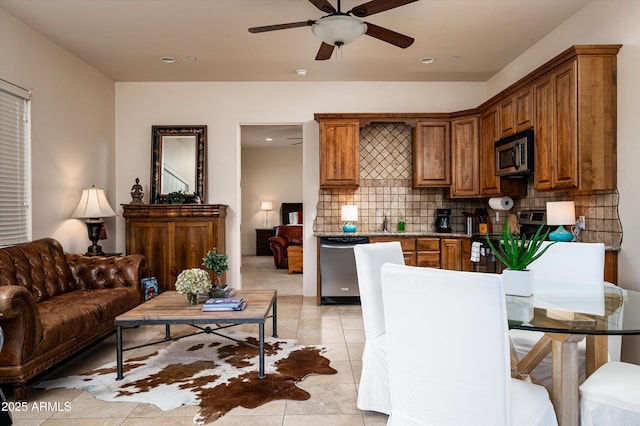 7025 E Ashler Hills Dr, Scottsdale, AZ 85266 - kitchen featuring stainless steel appliances, ceiling fan, brown cabinetry, tasteful backsplash, and light tile patterned floors