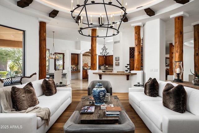 7025 E Ashler Hills Dr, Scottsdale, AZ 85266 - living area featuring a chandelier, wood finished floors, and ornate columns
