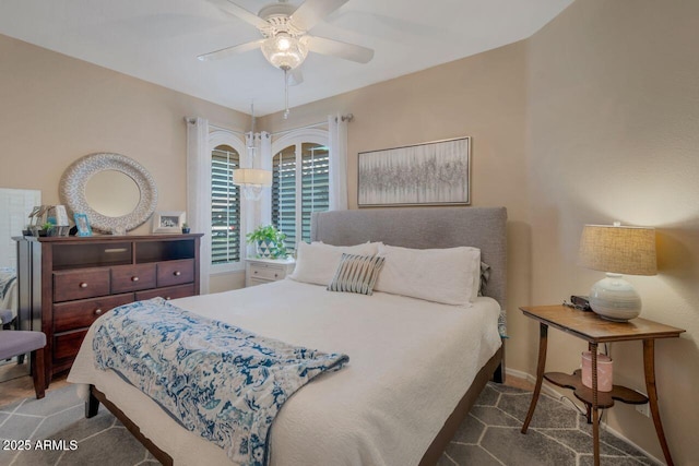 bedroom with a ceiling fan, dark colored carpet, and baseboards