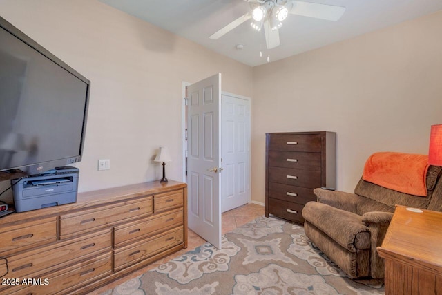 living area with light tile patterned floors and a ceiling fan