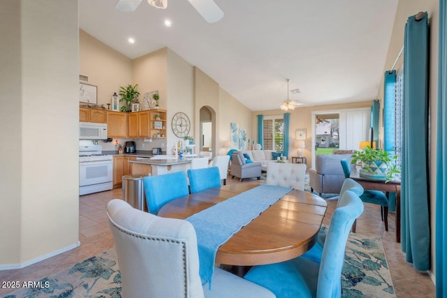 dining room with arched walkways, light tile patterned floors, recessed lighting, ceiling fan, and high vaulted ceiling