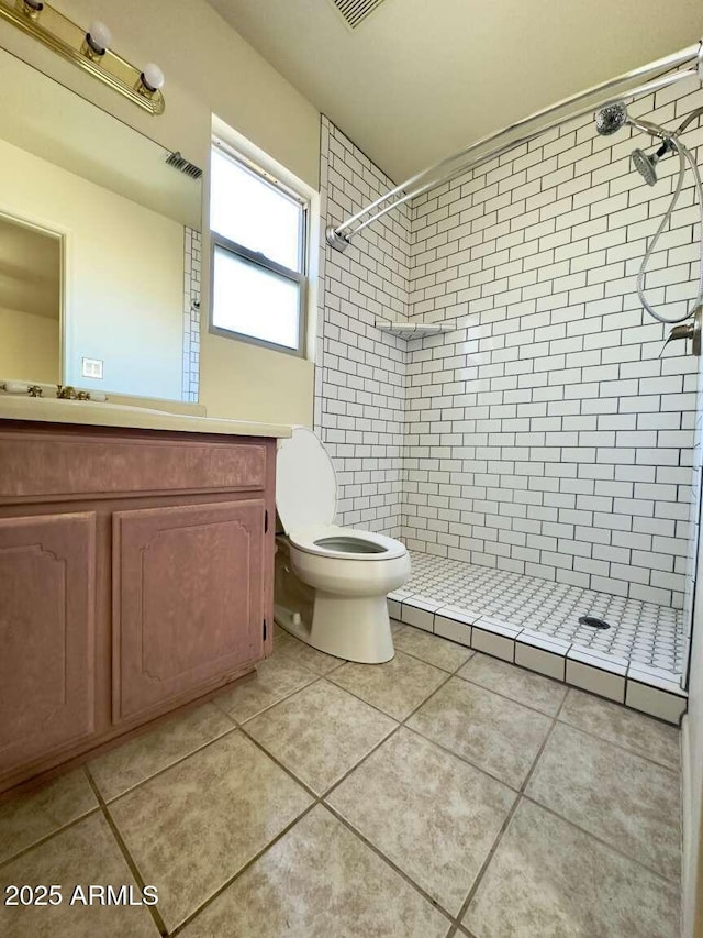 full bath featuring a stall shower, visible vents, toilet, tile patterned floors, and vanity