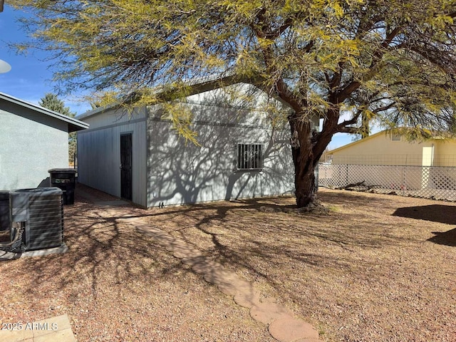 view of property exterior with fence and central air condition unit