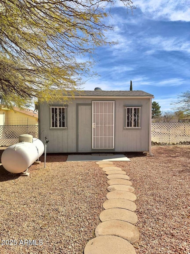 view of outbuilding featuring an outdoor structure and fence