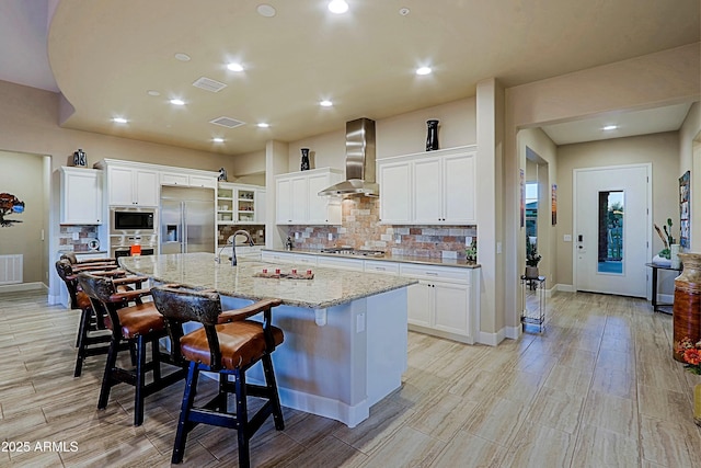 17249 E Fort Verde Rd, Rio Verde, AZ 85263 - kitchen featuring wall chimney exhaust hood, built in appliances, tasteful backsplash, white cabinetry, and recessed lighting