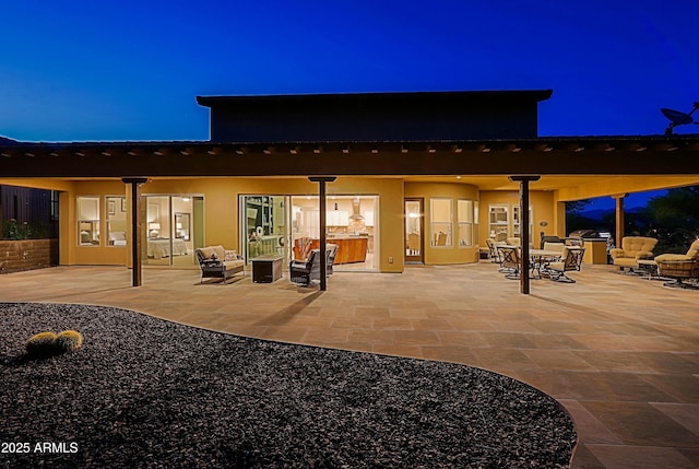 17249 E Fort Verde Rd, Rio Verde, AZ 85263 - back of house at twilight with an outdoor living space, stucco siding, outdoor dining space, and a patio