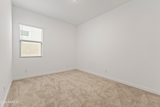 spare room featuring light colored carpet