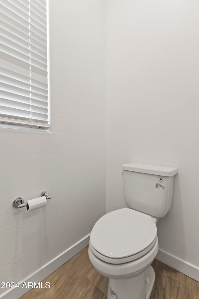 bathroom with hardwood / wood-style floors and toilet